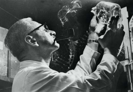 Dr. Albert Sabin, who developed an oral polio vaccine, looking for effects of virus damage to cells growing in a tissue-culture bottle. Credit: Bettmann Archive, via Getty Images